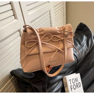 Detail view of the pink ruffled shoulder bag with dual bow accents and silver hardware