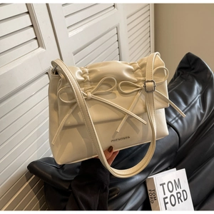 Detail of cream PU leather tote bag with double bow decoration and pleated design