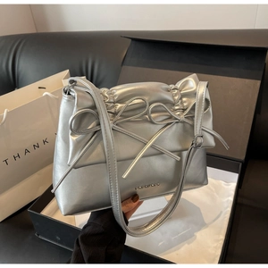Silver bow-knot shoulder bag detail with ruffled leather texture and metallic logo