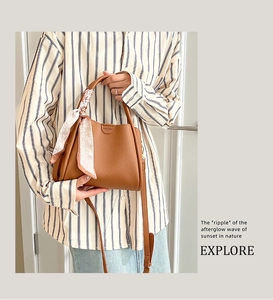Sac seau en cuir grainé marron avec un foulard en soie à motif cœurs sur la poignée