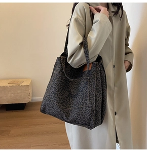 Detailed view of leopard print canvas tote bag with front pocket and leather patch detail