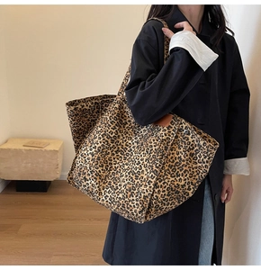 Detailed close-up of large canvas leopard print tote bag with metallic rivet accents