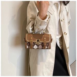 Detail of a brown argyle patterned leather crossbody bag on a beige trench coat