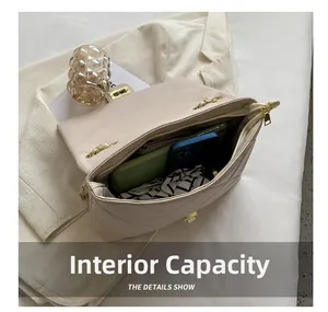 Internal capacity of beige quilted chain bag showing space for phones and accessories