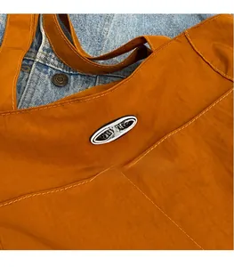 Detail of orange canvas tote bag showing the DOUGU rubber logo and stitching texture