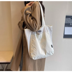 Detail of white large capacity tote bag with DOUGU logo and durable shoulder strap