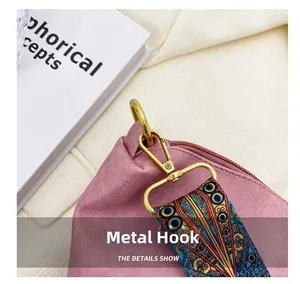 Close-up of golden hardware hook and colorful printed wide strap on pink leather bucket bag