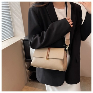 Detail of almond leather crossbody bag with wide strap and golden hardware closure