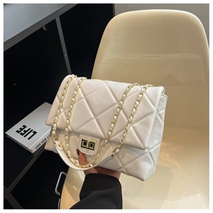 Detailed macro view of white quilted faux leather texture with golden chain strap