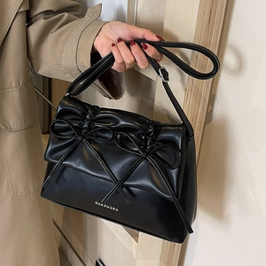 Minimalist black PU leather tote bag with dual bow accents and adjustable shoulder strap