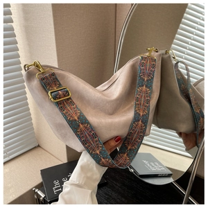Detail of soft beige slouchy hobo bag with a wide colorful geometric woven strap