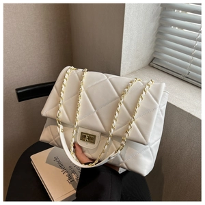 Close-up of white quilted leather bag featuring gold twist lock and chain strap detail