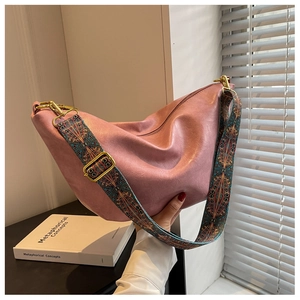 Detail view of pink crescent bag with geometric wide strap and gold hardware accents