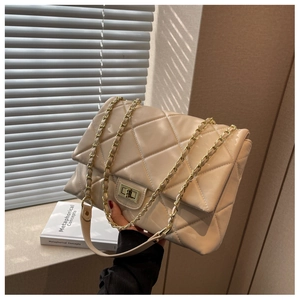 Detailed view of beige quilted bag with gold twist lock and leather chain strap