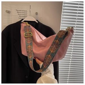 Detailed shot of pink faux leather bag with bohemian style wide patterned shoulder strap