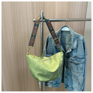 Detail of light green hobo bag with ethnic geometric pattern wide woven shoulder strap