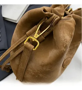 Detail of premium golden metal hardware and vintage matte leather on caramel bucket bag