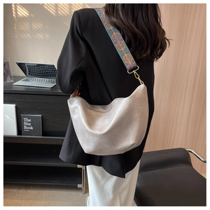 Hobo shoulder bag with colorful bohemian strap shown in a modern lifestyle setting