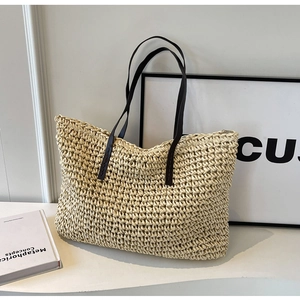 Detail of hand-woven straw tote with premium dark brown leather straps and texture