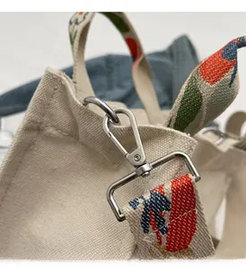 Detailaufnahme der Canvas-Beuteltasche mit farbigem Webgurt und silbernem Metallverschluss