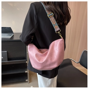 Detailed view of pink hobo bag with ethnic embroidery wide strap and gold hardware