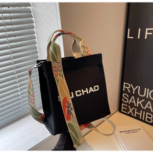Detail der Canvas-Eimertasche mit U CHAO-Schriftzug und floral bedrucktem breitem Schultergurt