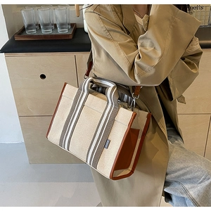 Sac cabas en toile avec garniture en cuir marron et étiquette SJCH porté en bandoulière