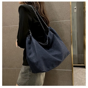 Détail du grand sac cabas en denim bleu foncé avec bandoulière chaîne argentée