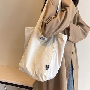 Minimalist beige large canvas tote bag shown on shoulder in stylish interior setting