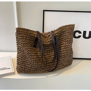 Close-up of the woven texture and premium brown leather handles on this beach tote bag