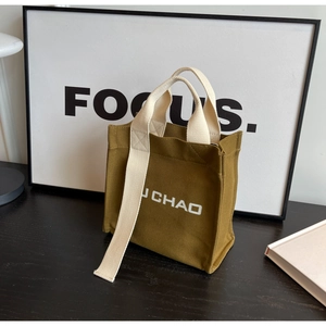 Detailansicht der olivgrünen Canvas-Beuteltasche mit breitem Gurt und J CHAO Logoaufdruck