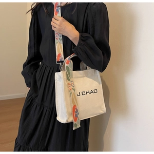 Nahaufnahme der Canvas-Beuteltasche mit besticktem Gurt und J CHAO Logo-Aufdruck