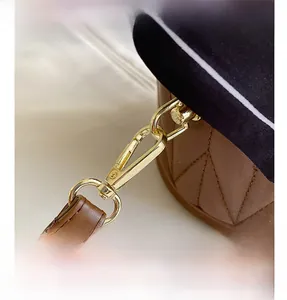 Detailed macro view of golden hardware and quilted brown leather bucket bag textures