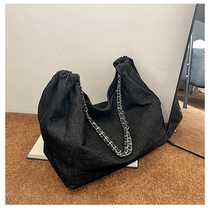 Vue détaillée du grand sac cabas en denim noir avec texture en tissu et chaîne argentée