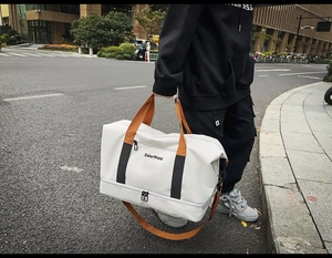 Detail der Reisetasche mit orangefarbenen Griffen und separatem Boden-Reißverschluss