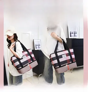 Vue détaillée du sac de voyage Oxford à carreaux montrant les modes épaule et main