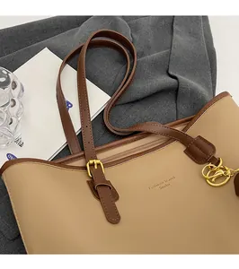 Close-up of adjustable strap, golden buckle and embossed logo on beige tote bag