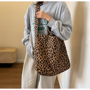 Close-up of leopard print canvas tote bag styled with casual outfit in soft lighting