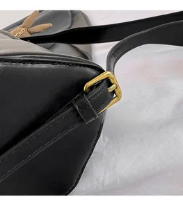 Close-up of premium black leather texture with durable vintage gold metal buckle