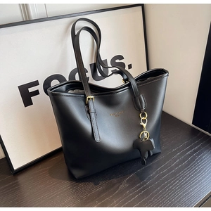 Macro shot of black tote bag with adjustable strap and fashion trend gold lettering