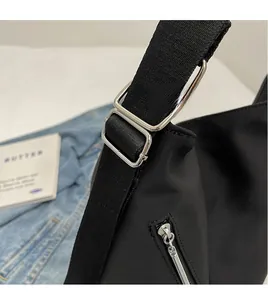Detail of adjustable black woven strap and silver metal buckle on a casual tote bag