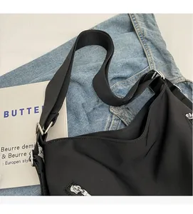 Close-up of black nylon tote bag with silver metal zipper and durable shoulder strap