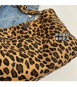 Dettaglio della borsa tote leopardata con bottone a pressione e fibbia in metallo