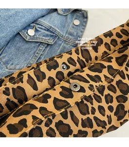 Dettaglio della borsa tote in tela leopardata con chiusura a scatto in metallo