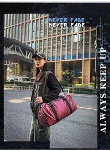 Detail of burgundy oxford cloth tote bag with black straps in an urban street style view
