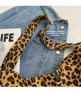 Dettaglio della tracolla regolabile e fibbia in metallo sulla borsa tote leopardata in tela