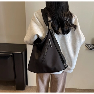 Rear view of a black large capacity nylon tote bag with a unique triangular silhouette