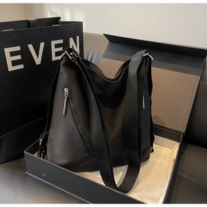 Minimalist black tote bag in a luxury gift box with decorative vertical zipper and strap