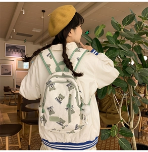 Detail view of large capacity white and green school backpack with cute bear pattern