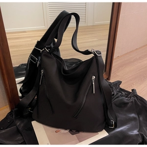 Detail of waterproof nylon tote bag with silver zippers and multi-way straps